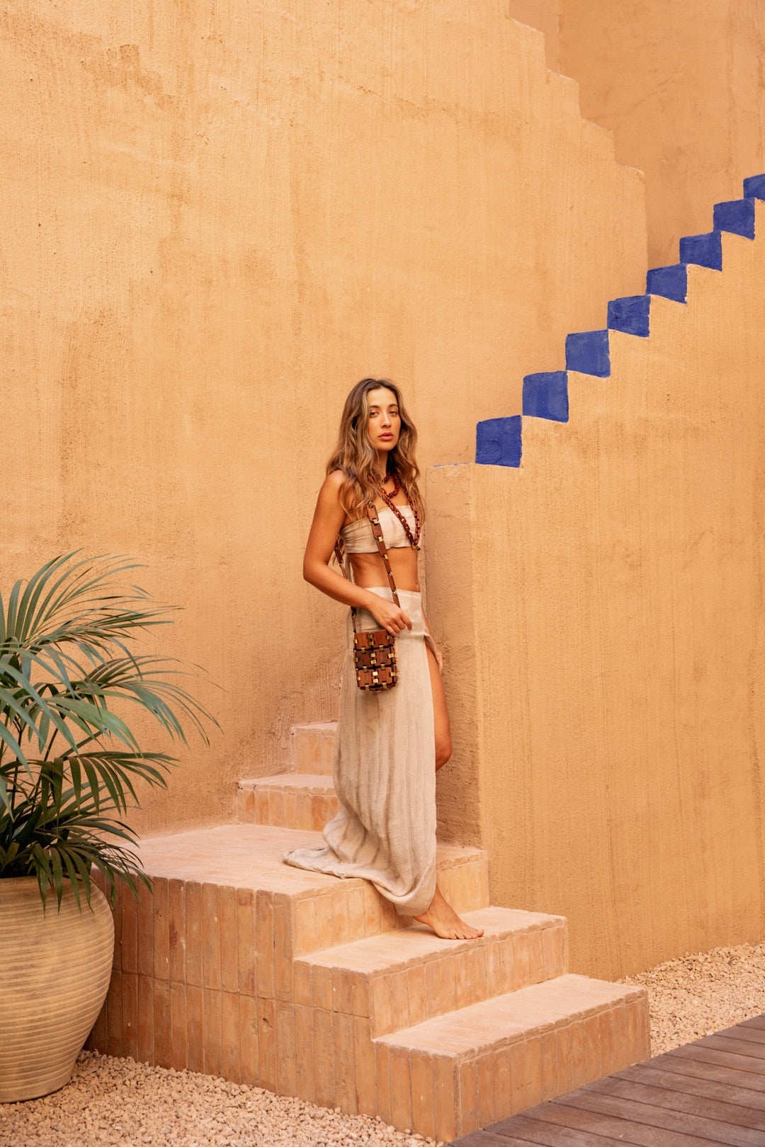 Model wearing the Sage Bag on ochre steps